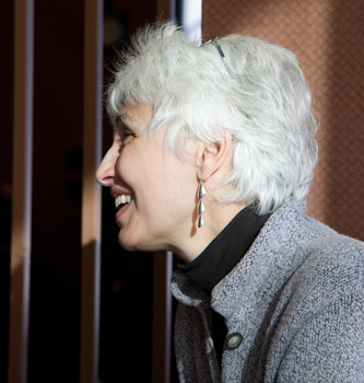 Maureen Banner and her white hair and earrings she made. Photo by Pat Arnow