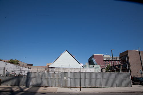 A lot that used to have houses and now is surrounded by a metal fence on 175th St. Photo by Pat Arnow