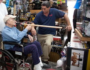 Irv Fishman examines a stickball bat in Frank's Sport Shop, Tremont Ave., Bronx. Photo by Pat Arnow.